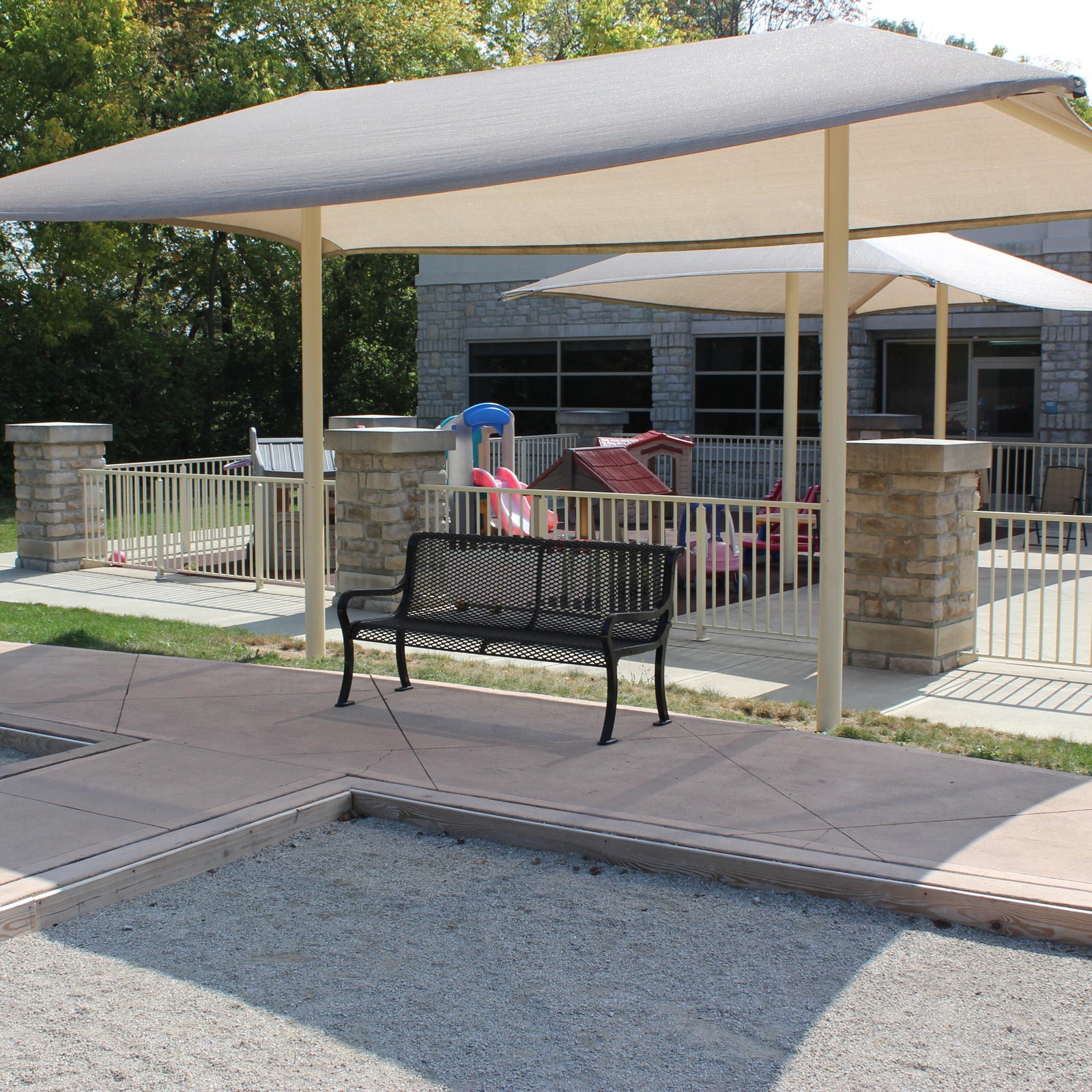 Patio with a covered area, bench, and playground equipment.